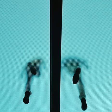 two-people-standing-on-glass-floor-seen-from-underneath
