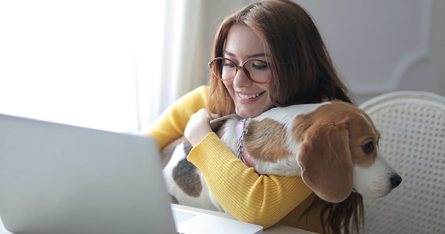 Kvinna med hund framför dator