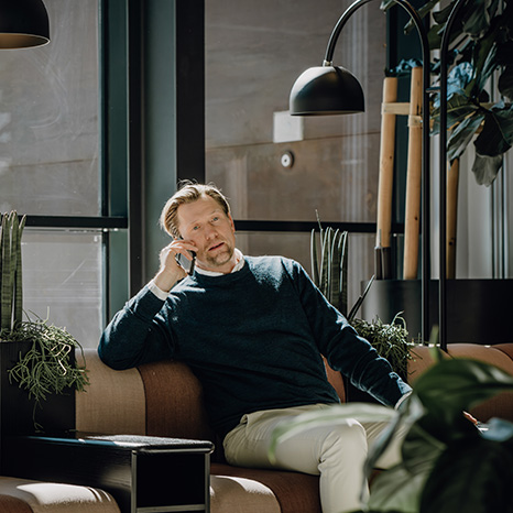 man sitter i fåtölj och pratar i telefon