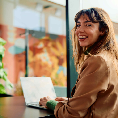 kvinna som ler framför datorn